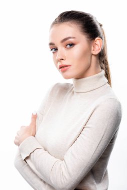 Doğal makyajlı güzel bir kadın kollarını kavuşturup beyaza izole edilmiş kameraya bakıyor.