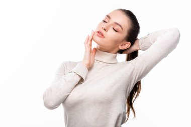 Doğal makyajlı çekici bir kız. Yüzüne dokunuyor. Gözleri kapalı, beyaz tenli.