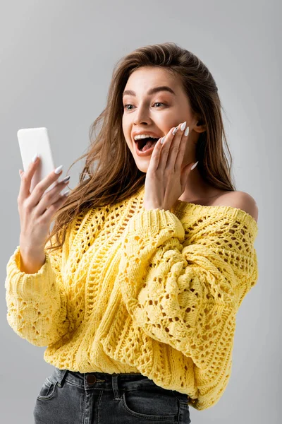 Menina Surpreso Tocando Rosto Durante Chamada Vídeo Smartphone Isolado Cinza — Fotografia de Stock