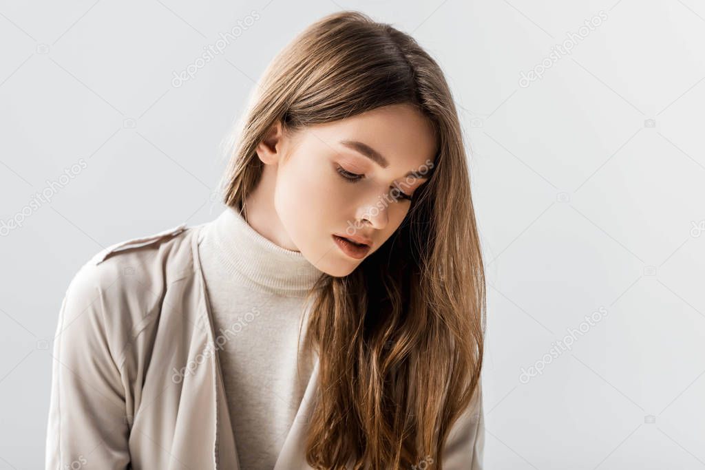 dreamy, stylish woman looking down isolated on grey
