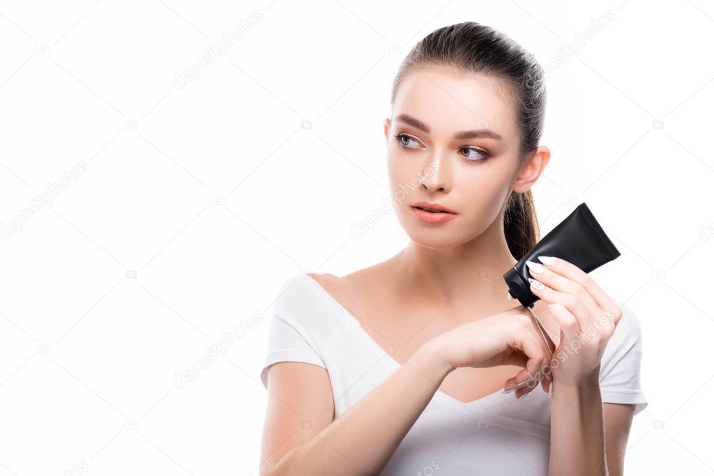 attractive girl looking away while applying hand cream isolated on white