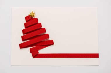 Altın yıldız şekilli kırmızı kurdelenin üst görüntüsü beyaz üzerine izole edilmiş kağıt zarf üzerinde yay 