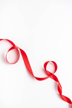 top view of red and curled ribbon on white  clipart