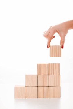 cropped view of woman putting wooden cube on white  clipart