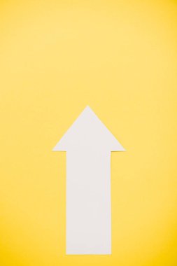 top view of white arrow isolated on yellow  clipart