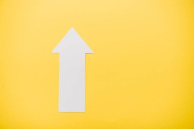 top view of white arrow isolated on yellow with copy space  clipart