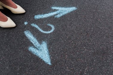 Doğrusal oklar ve asfaltta soru işareti olan bir kadının kesikli görüntüsü 