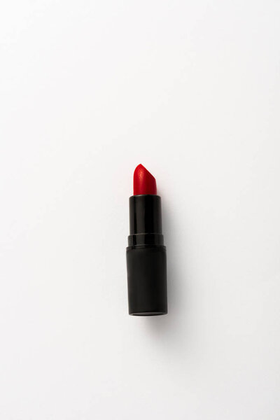 top view of black tube with red lipstick on white with copy space 