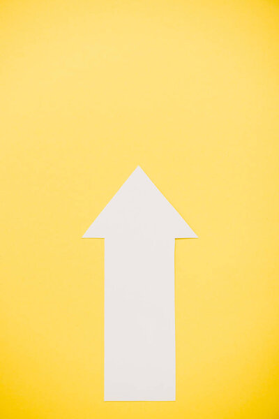 top view of white arrow isolated on yellow 