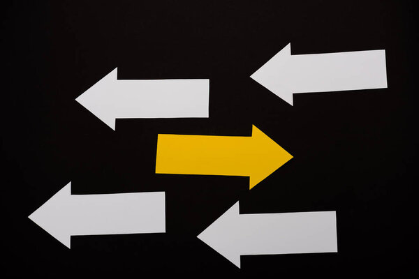 верхний вид направленных белых и желтых стрелок, изолированных на черном
 