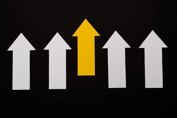 top view of white and yellow arrows isolated on black 