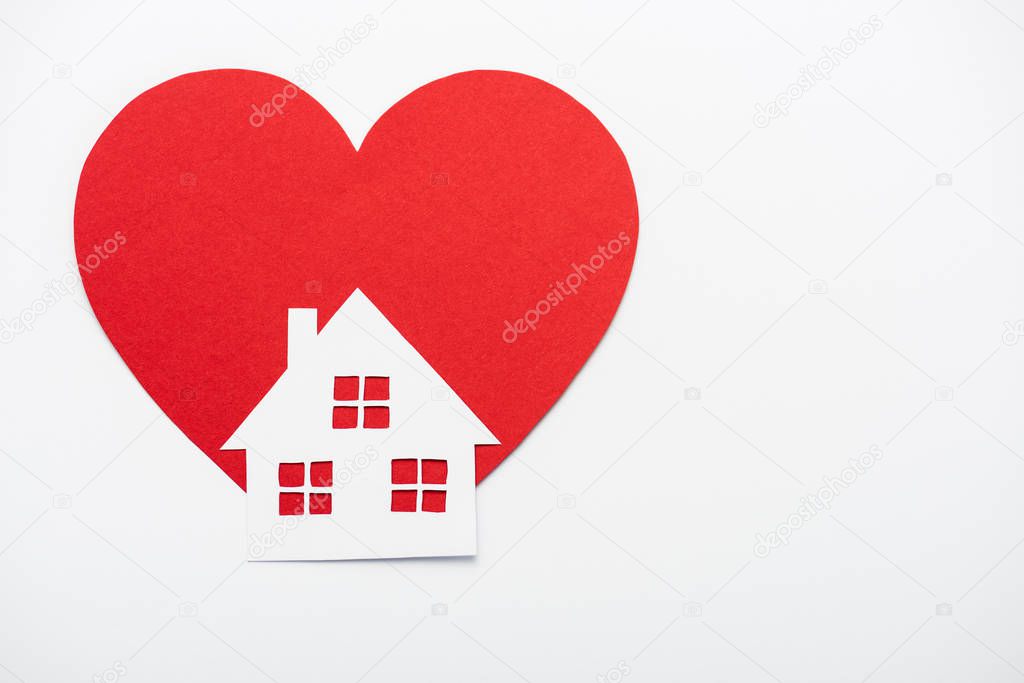 red heart near paper house isolated on white with copy space