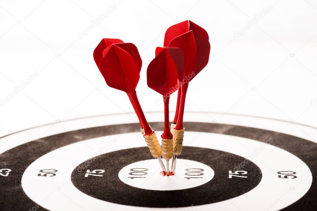 close up of black and white dartboard with red arrows isolated on white 