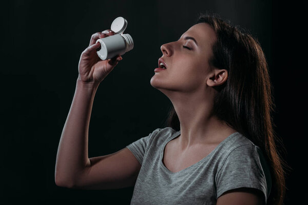 отчаявшаяся женщина, совершившая самоубийство, принимая передозировку лекарств, изолированных на черном
