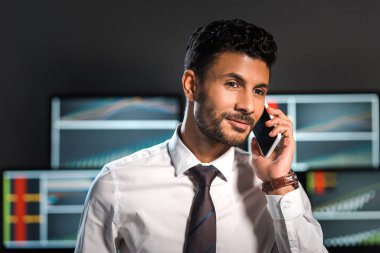 Akıllı telefondaki gülümseyen çift ırklı tüccarın seçici odak noktası 