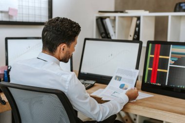 Ofisteki kağıda bakan çift ırklı tüccarın seçici odak noktası 