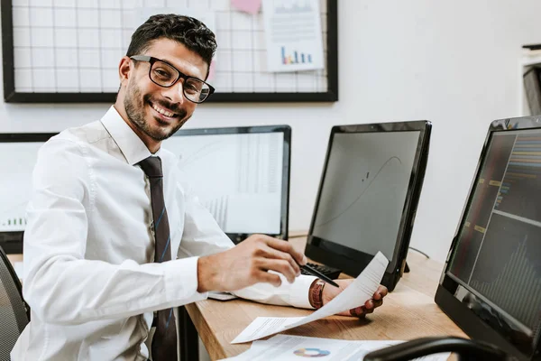 Glimlachende Raciale Handelaar Die Papier Vasthoudt Naar Camera Kijkt — Stockfoto