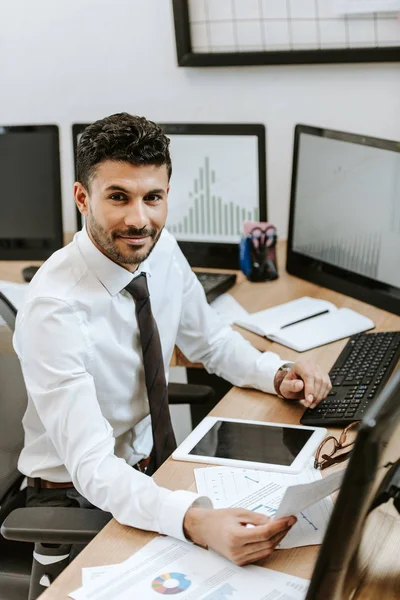 Glimlachende Raciale Handelaar Die Papier Vasthoudt Aan Tafel Zit — Stockfoto