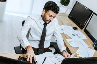 Ofiste evrak işi yapan iki ırklı tüccarın yüksek açılı görüntüsü 