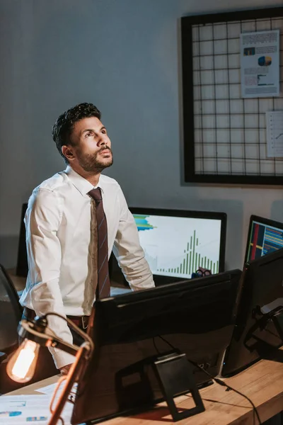 Zweirassiger Händler Steht Der Nähe Des Computers Und Schaut Auf — Stockfoto