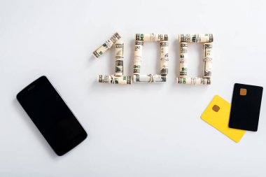 Para rulolarının yanında boş ekranı ve beyaz kart şablonlarıyla akıllı telefonun üst görünümü 