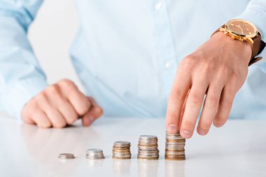 cropped view of man touching stack of coins isolated on white  clipart