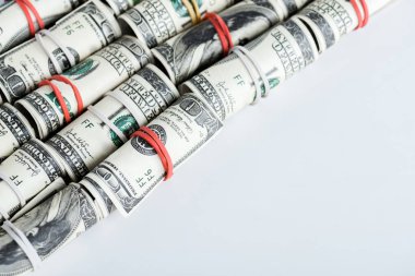 Dolar banknotları para ruloları ve renkli lastik bantlar beyaz üzerine 