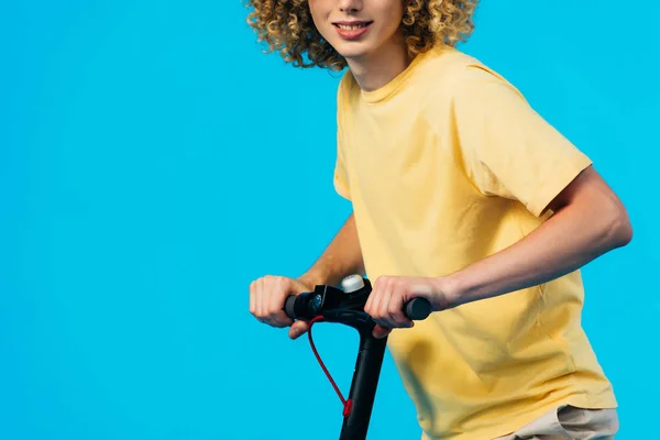 Vista Cortada Adolescente Encaracolado Sorridente Montando Scooter Elétrico Isolado Azul — Fotografia de Stock