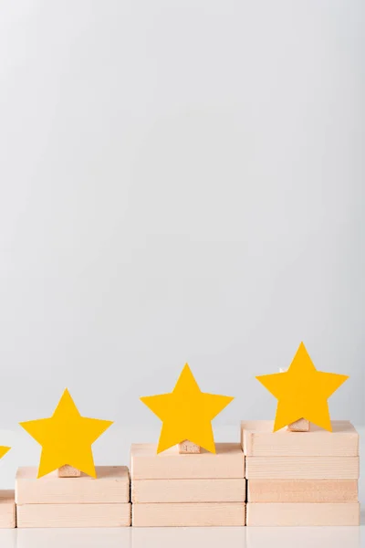 yellow stars on wooden blocks as career growth concept isolated on white 