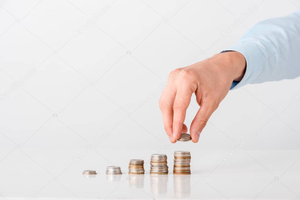 cropped view of man taking coin from stack on white 