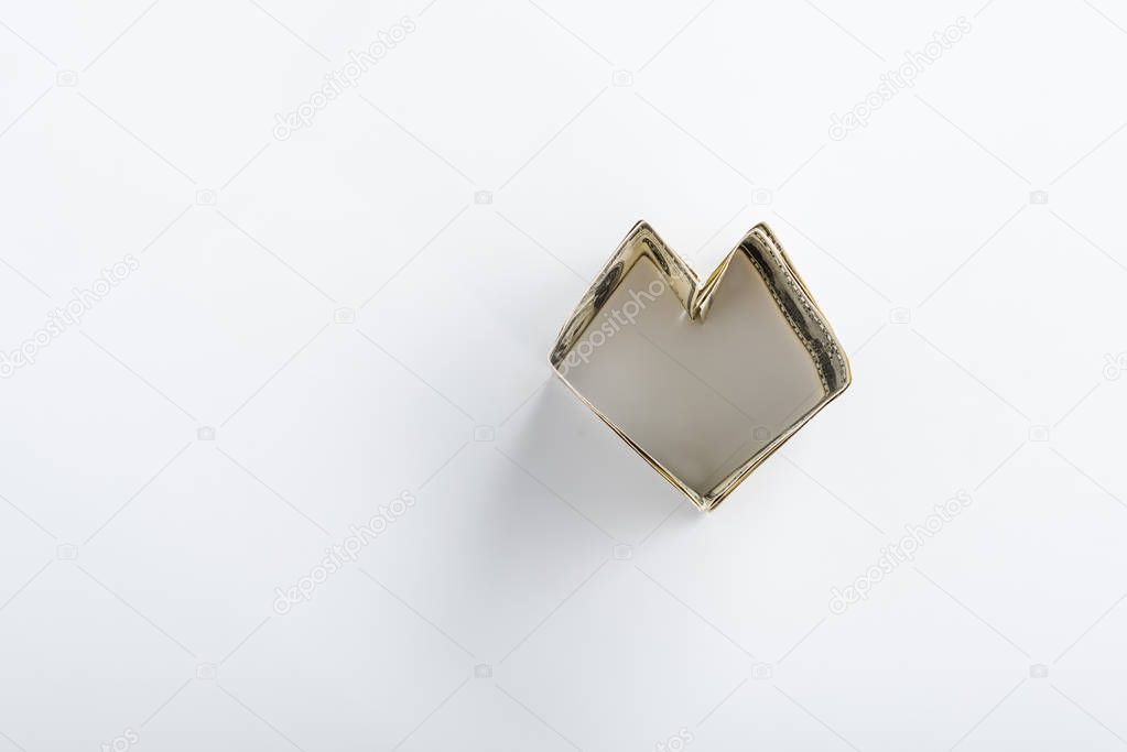 top view of heart-shaped dollar banknotes on white with copy space