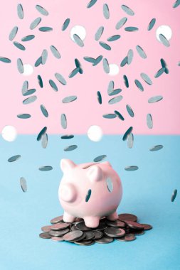 Düşen gümüş paralar Mavi ve Pembe kumbaranın yanında 