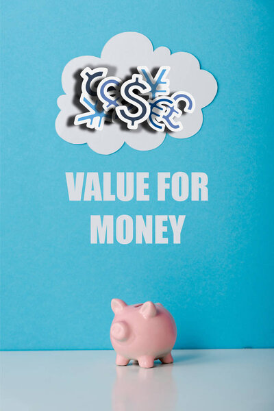 pink piggy bank near white cloud and value for money letters on blue 