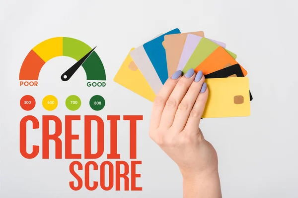 白い文字とグラフの近くにカラフルなクレジットカードテンプレートを保持している女性のクロップドビュー — ストック写真
