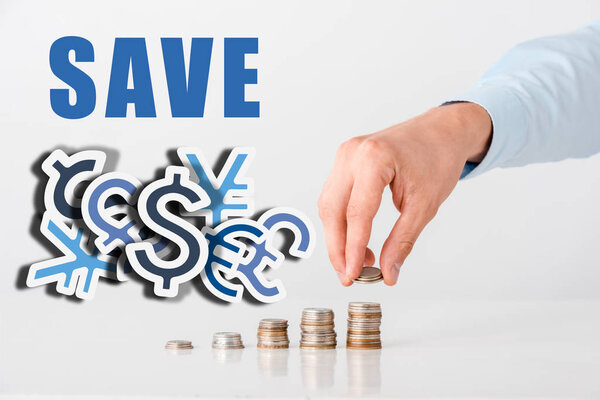 cropped view of man touching stack of coins near save letters and on white 