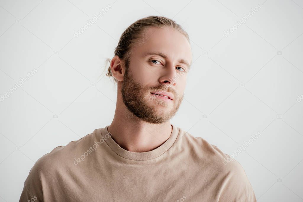 young handsome man in beige outfit looking at camera isolated on white