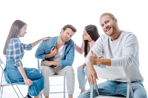坐在多元文化支持团体旁边 与白人隔离的椅子上 快乐男人竖起大拇指的选择性焦点 — 图库照片