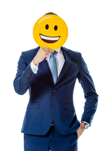 KYIV, UKRAINE - AUGUST 12, 2019: businessman in blue suit holding happy smiley in front of face isolated on white