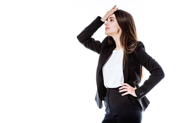 stressed businesswoman in suit with hand on hip touching head isolated on white