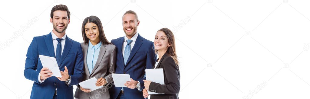 smiling multicultural business people in suits holding digital tablets isolated on white, panoramic shot