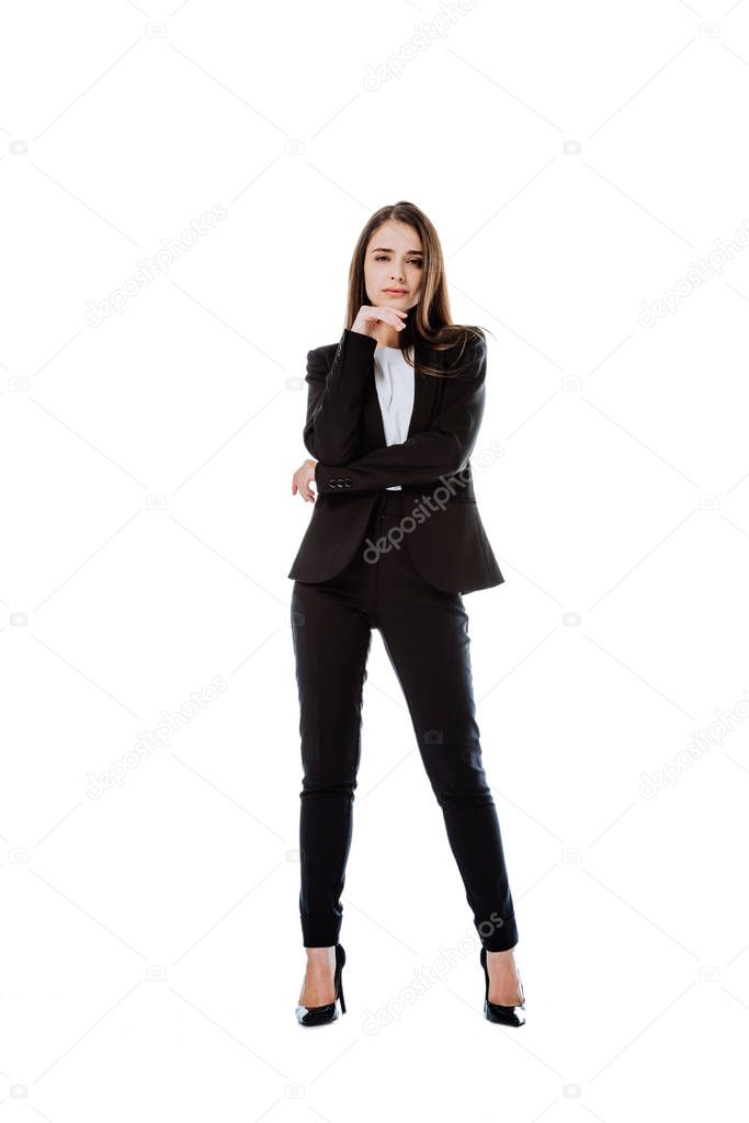 full length view of confident businesswoman in suit posing isolated on white