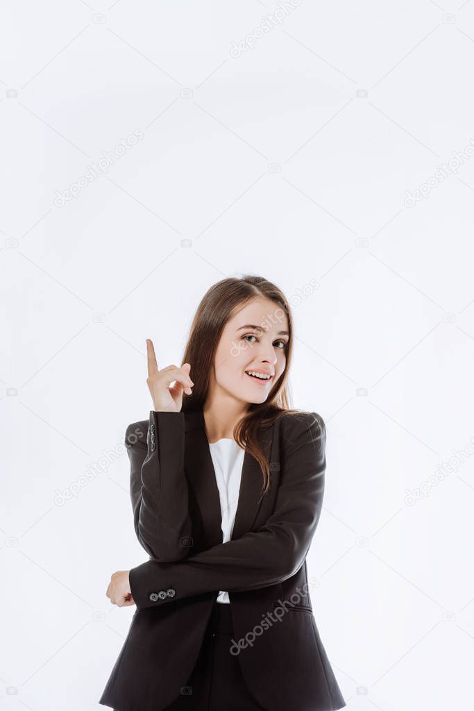 smiling confident businesswoman in suit pointing with finger up isolated on white