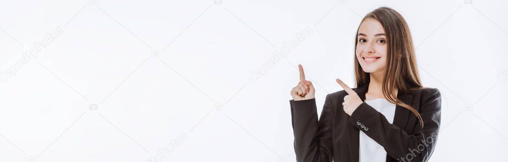 smiling businesswoman in suit pointing with fingers up isolated on white, panoramic shot