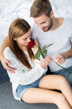 Yakışıklı bir adamın çekici bir kadına sarılıp ona gül vermesi. 