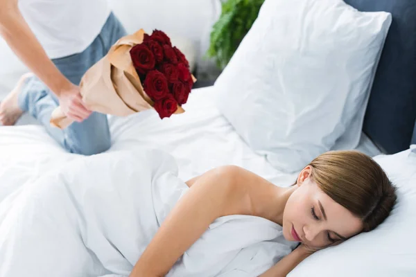 Cropped View Man Holding Bouquet Woman Sleeping Bed — Stock Photo, Image