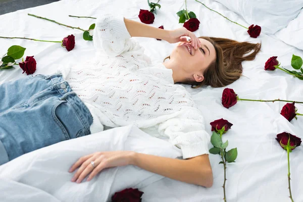 Усміхнена Жінка Затемнює Обличчя Лежить Ліжку Трояндами — стокове фото