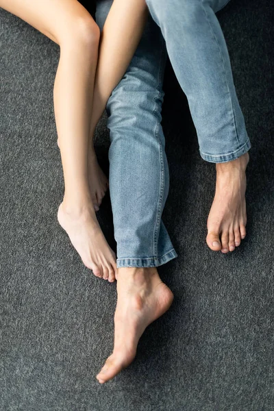 床に座っている男性と女性のクロップドビュー — ストック写真