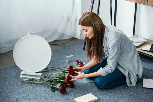 在被抢劫的公寓里捧着花的漂亮而悲伤的女人 — 图库照片