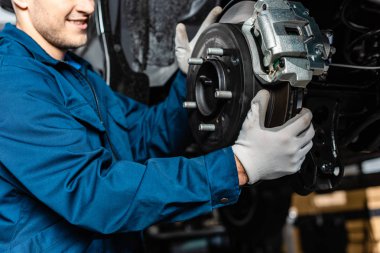 cropped view of mechanic adjusting disc brakes  clipart