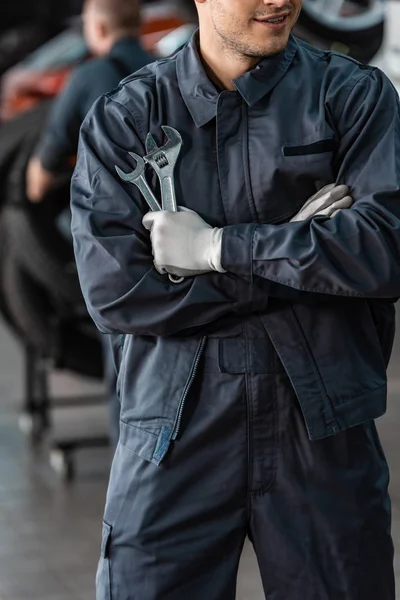 Cropped View Young Mechanic Standing Crossed Arms Holding Wrenches — Stock Photo, Image